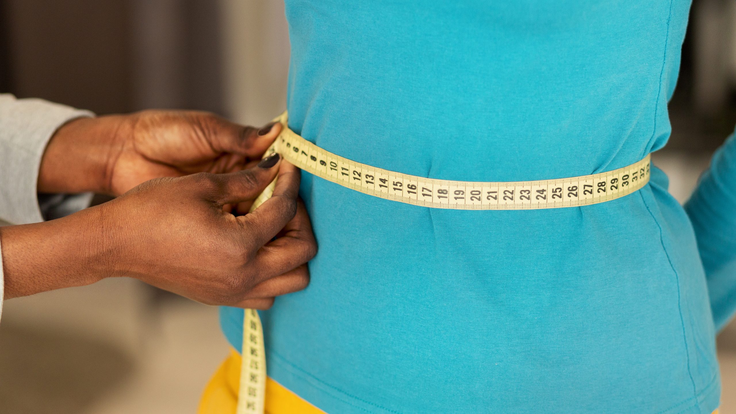 Waist circumference being measured with a tape measure