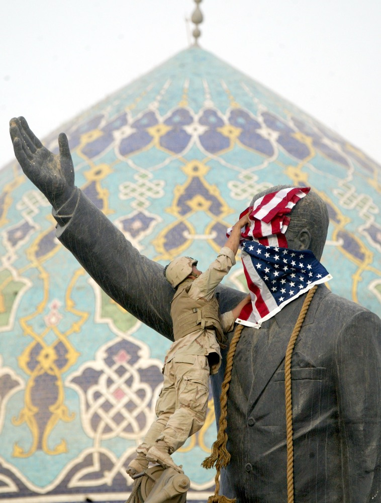 Photograph of Toppling of Statue of Saddam Hussein with U.S. Flag, 2003 (Firdos Square, Baghdad). Photo by Gerard Van der Leun, CC BY-NC-ND 2.0.