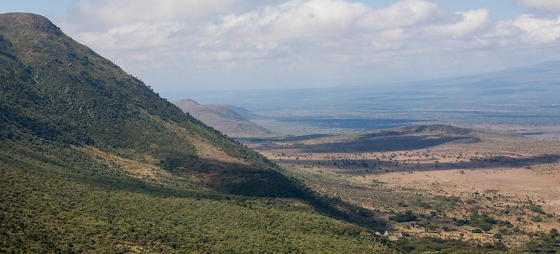 Patchy green mountain alongside a deep sandy valley in East Africa.
